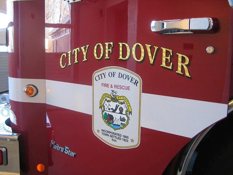 Close detail of the City of Dover Fire & Rescue crest on the side of a red fire apparatus