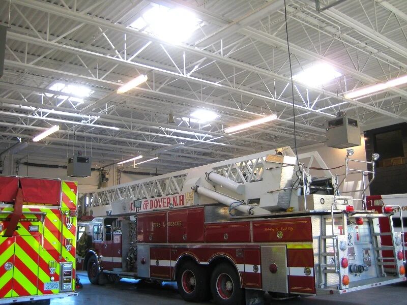 Ladder truck parked under high-bay lighting inside the Sixth Street fire station apparatus bay in Dover, New Hampshire