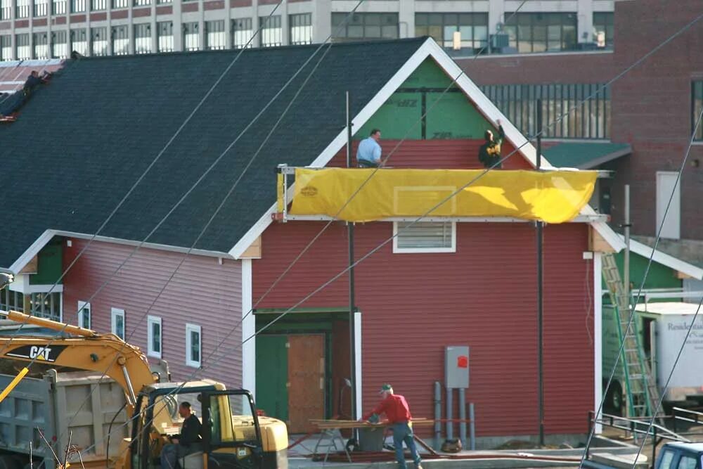 The Friendly Kitchen building under construction in Concord, New Hampshire, with an excavator and lift on site and sheathing still exposed at the gable