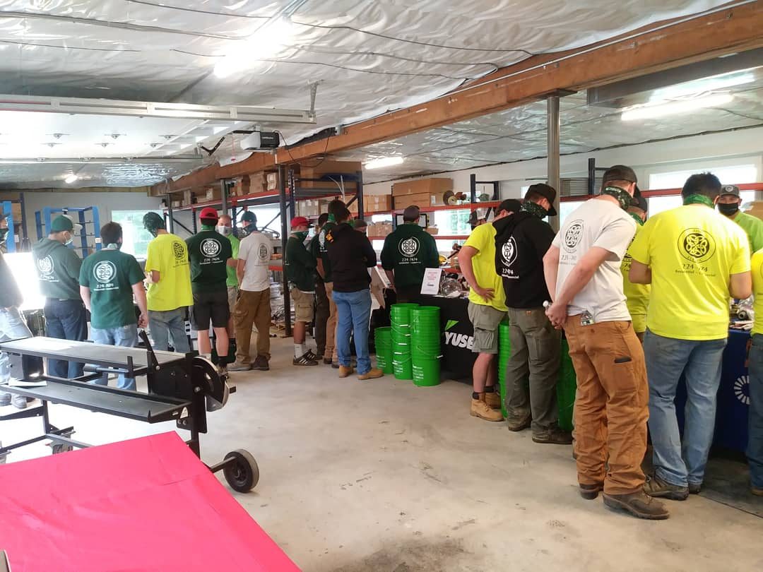 Irish Electric crew in green and yellow company shirts gathered in the Hopkinton shop