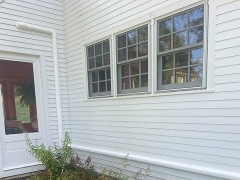 White line set cover running down the corner and along the base of a white clapboard house