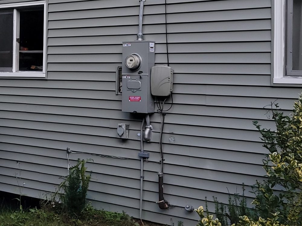 A single new meter socket with a service disconnect on the same house wall after the service change