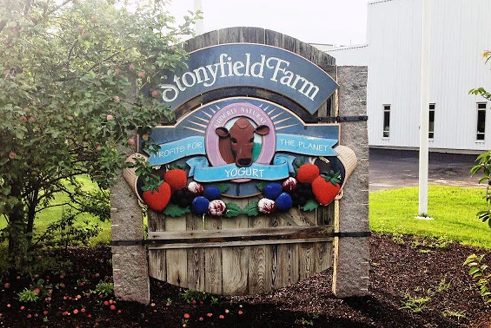 Carved Stonyfield Farm entrance sign in front of the plant building in Londonderry, New Hampshire
